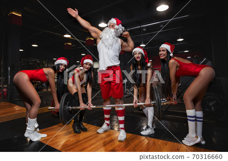 Santa Claus with girls in Santa's hats in a gym 70316660