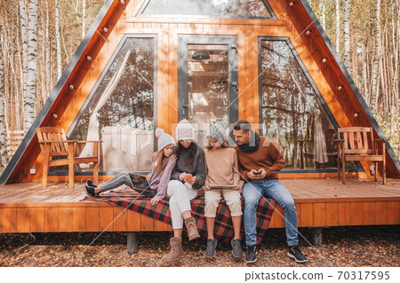 Happy family sitting on the terrace of their house in autumn 70317595