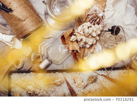 a lot of sea theme in mess like shells, candles, perfume, girl stuff on linen, pretty textured post card view vintage 70318291