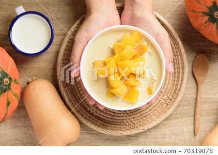 Thai sweet food, pumpkin in sweet coconut milk holding by hand Thai sweet food, pumpkin in sweet coconut milk holding by hand 70319078