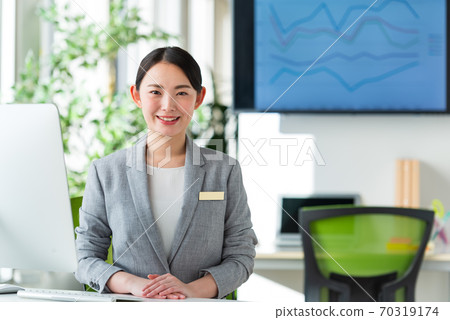 A young business woman working by the window in a bright office A young business woman working by the window in a bright office 70319174