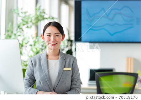 A young business woman working by the window in a bright office 70319176