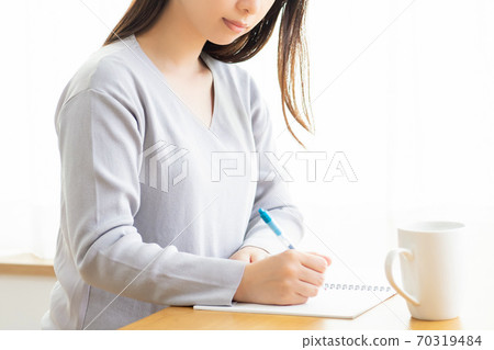 年輕女子在筆記中寫筆記 年輕女子在筆記中寫筆記 70319484