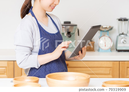 Young woman standing in the kitchen Young woman standing in the kitchen 70319909