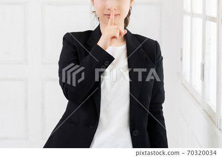 Young business woman who hides her mouth Young business woman who hides her mouth 70320034
