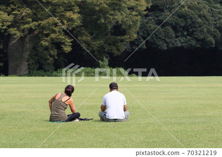 Two men and women relaxing in the park 70321219