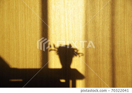 背面的摺痕反射出明媚的陽光透過房間的窗戶照到的家具的陰影 70322041