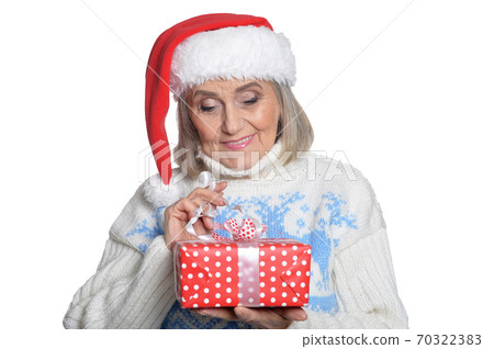 Portrait of smiling senior woman in Santa hat posing 70322383