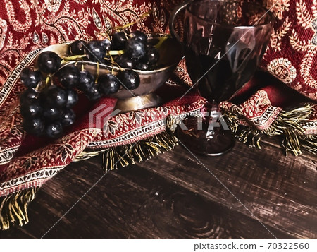 Rose wine bottle on the table, a couple of glasses and a beautiful cat 70322560