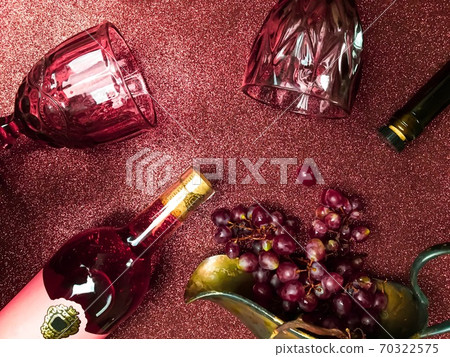 Rose wine bottle on the table, a couple of glasses and a beautiful cat Rose wine bottle on the table, a couple of glasses and a beautiful cat 70322575