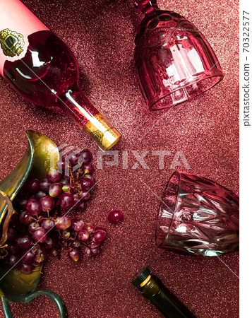 Rose wine bottle on the table, a couple of glasses and a beautiful cat Rose wine bottle on the table, a couple of glasses and a beautiful cat 70322577