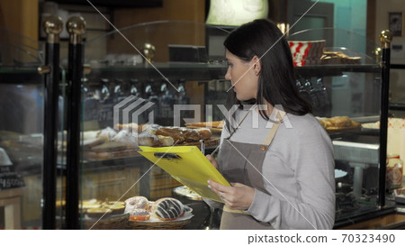 Young female baker working at her store Young female baker working at her store 70323490