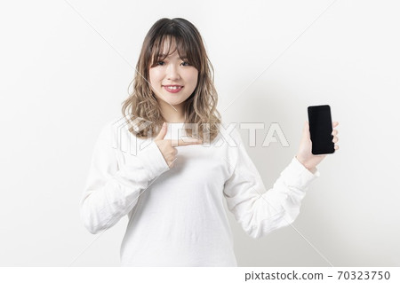 A young woman using a smartphone 70323750