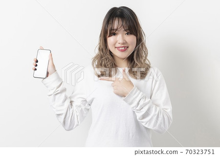 A young woman using a smartphone 70323751
