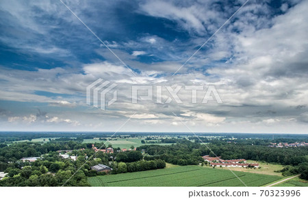 Aerial view of an area of arable land at the edge of a village 70323996