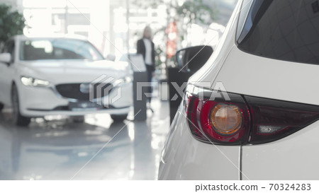 Female customer choosing automobile to buy at dealership salon 70324283
