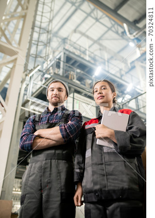 Young successful male and female engineers of large contemporary warehouse Young successful male and female engineers of large contemporary warehouse 70324811