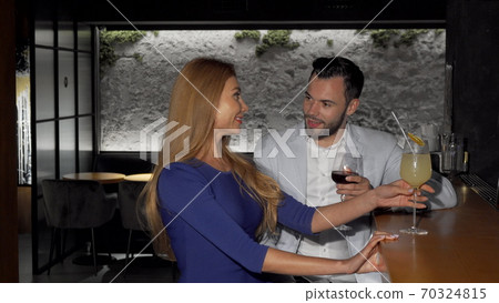 Handsome man enjoying drinks with his girlfriend at the bar 70324815