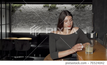 Young beautiful woman drinking cocktail at the bar counter Young beautiful woman drinking cocktail at the bar counter 70324842