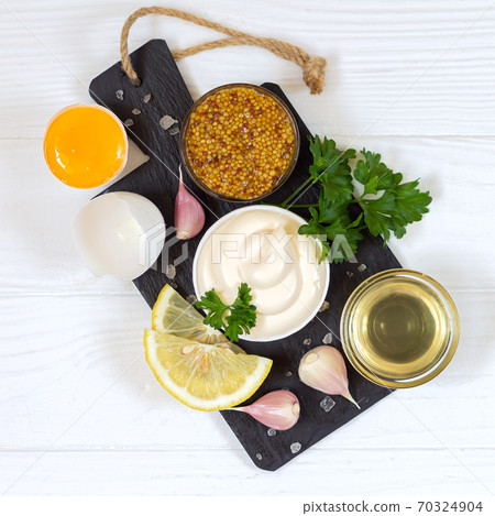 Ingredients for making mayonnaise sauce on stone board top view Ingredients for making mayonnaise sauce on stone board top view 70324904