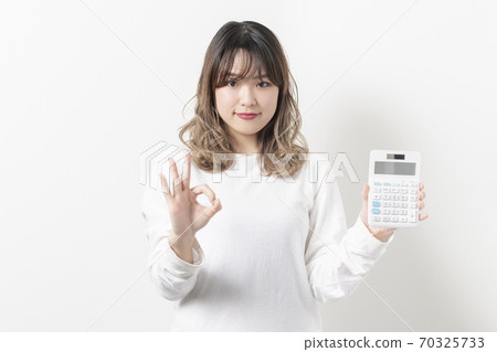 Young woman using a calculator Young woman using a calculator 70325733