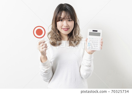 Young woman using a calculator 70325734