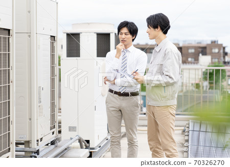 A businessman who inspects the outdoor unit A businessman who inspects the outdoor unit 70326270