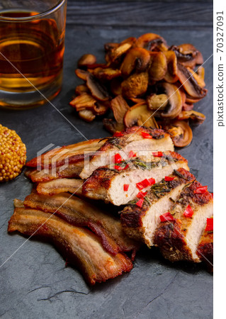 Roasted meat served with fried mushrooms and slice of bacon, mustard and glass of bourbon Roasted meat served with fried mushrooms and slice of bacon, mustard and glass of bourbon 70327091