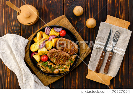 Fried beef fillet with potato wedges served with fresh onion, tomato and honey mushrooms gravy Fried beef fillet with potato wedges served with fresh onion, tomato and honey mushrooms gravy 70327094