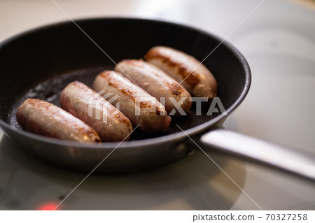 five sausages fried in pan. semi-finished products 70327258