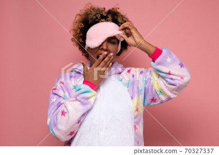 Yawning tired young african woman in pajamas. Yawning tired young african woman in pajamas. 70327337
