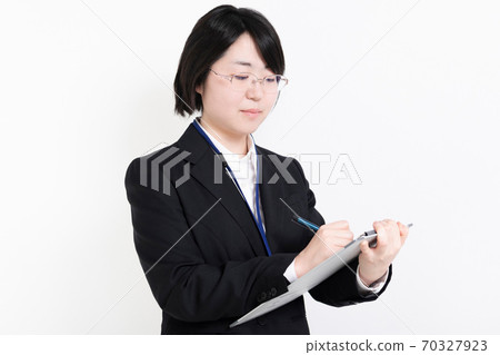 Business woman writing notes on the clipboard 70327923