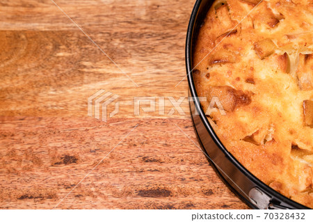 fragment of homemade cake in pan on wooden Board. fragment of homemade cake in pan on wooden Board. 70328432