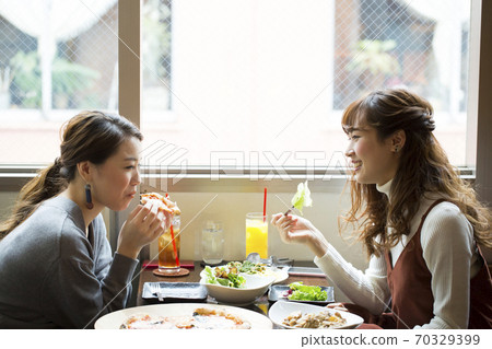 A woman dining at a cafe 70329399