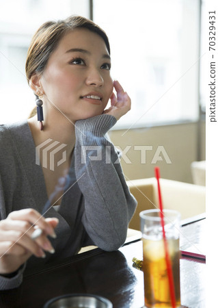 A woman smoking a cigarette A woman smoking a cigarette 70329431