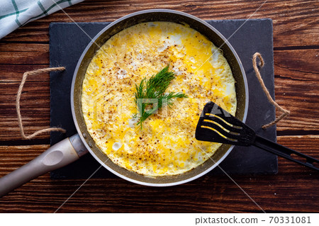 close up. home omelet with herbs in pan on wooden. close up. home omelet with herbs in pan on wooden. 70331081