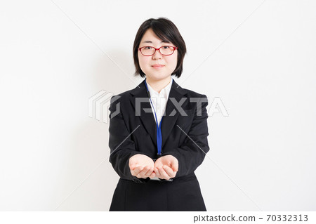 A woman in a suit holding out her hands A woman in a suit holding out her hands 70332313