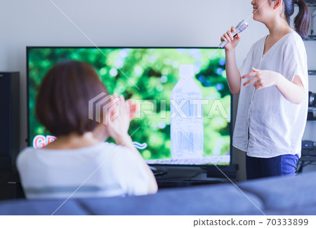 一個家庭（父母和兒童）可以通過家用遊戲機應用程序享受“家庭卡拉OK”的場景 70333899