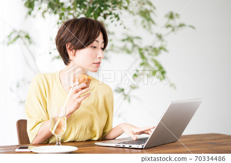 一個女人在一家咖啡館吃糖果 一個女人在一家咖啡館吃糖果 70334486