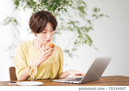 一個女人在一家咖啡館吃糖果 一個女人在一家咖啡館吃糖果 70334487