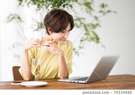 一個女人在一家咖啡館吃糖果 一個女人在一家咖啡館吃糖果 70334488