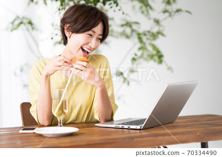 一個女人在一家咖啡館吃糖果 一個女人在一家咖啡館吃糖果 70334490