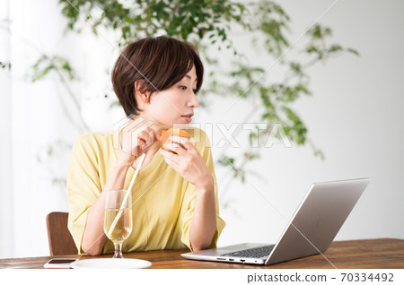 一個女人在一家咖啡館吃糖果 一個女人在一家咖啡館吃糖果 70334492