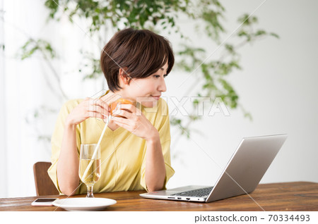 一個女人在一家咖啡館吃糖果 一個女人在一家咖啡館吃糖果 70334493