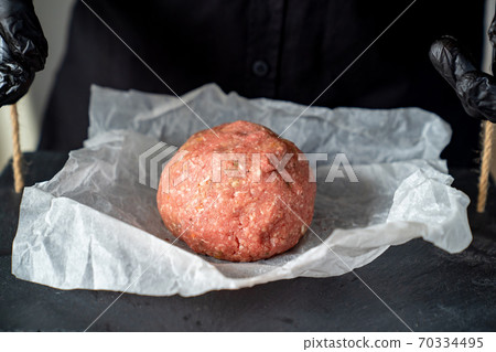 minced meat on paper, stone tray, black gloves minced meat on paper, stone tray, black gloves 70334495