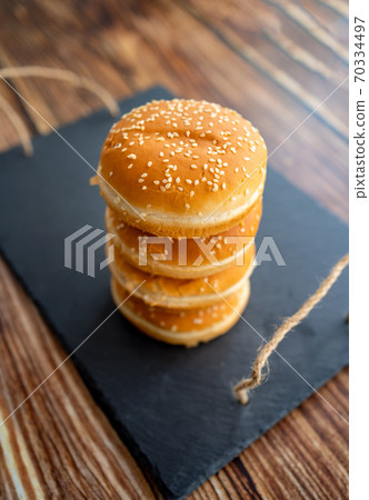 buns with sesame for burgers. black stone tray. buns with sesame for burgers. black stone tray. 70334497