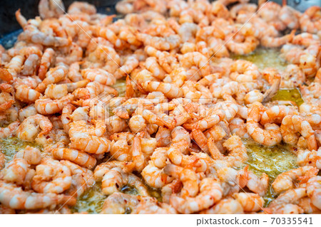 seafood street food. king prawns fried in  pan.  70335541