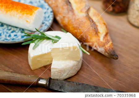 French cheese and fresh baguette on a wood cutter French cheese and fresh baguette on a wood cutter 70335968