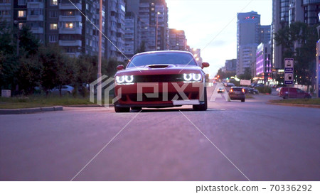 Red Sports Car Coupe Rear View In The Street. Classic powerful car in the city traffic. 70336292