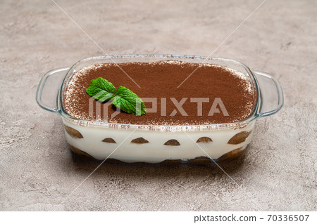 Traditional Italian Tiramisu dessert in glass baking dish on concrete background 70336507